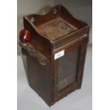 An Edwardian oak smoker's cabinet, with a single glazed door, height 32.5cm and a pipe.