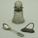 A silver mounted cut glass toilet bottle, a silver teaspoon and a silver plated decanter label.