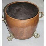 A large copper log bucket, circa 1900, with brass lions paw feet, height 36cm, diameter 41cm.