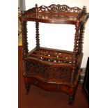 A Victorian figured walnut veneered Canterbury whatnot, with pierced gallery,