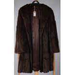 A dark brown lady's mink coat, with patterned, dark brown, silk lining, length 87cm, size 10/12.