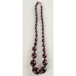 A faceted 'cherry amber' necklace, 50g.