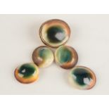 A high purity, gold mounted, operculum shell brooch and four unmounted shells.
