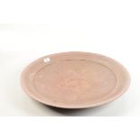 A studio pottery circular stoneware dish, by John Dunn, raku fired in shaded iridescent pink,