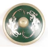 A circular metal shield painted with two griffins, diameter 58cm, depth 13cm.
