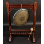 A Arts and Crafts mahogany framed circular metal gong, with turned and fluted columns on splay feet,