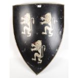 A metal shield painted with three lions, height 79cm, width 60cm.