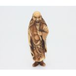 A ivory netsuke carved as a man, early 20th century, height 7.8cm, width 2.7cm.