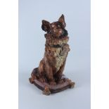 A pottery jar and cover in the form of a dog seated on a cushion,