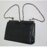 A black crocodile leather handbag, with suede lining and brass chain shoulder strap, 16.5 x 23cm.