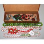 Costume necklaces and other jewellery including a necklace with glass flowers in a jewellery box.