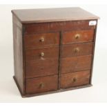 A miniature chest of drawers, early 20th century, the lift up top above eight drawers, height 35.