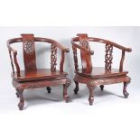 A pair of Chinese huali wood tub armchairs, each with a central vertical carved splat,