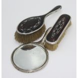Two silver mounted pique hairbrushes and a silver mounted chagrin hand mirror.