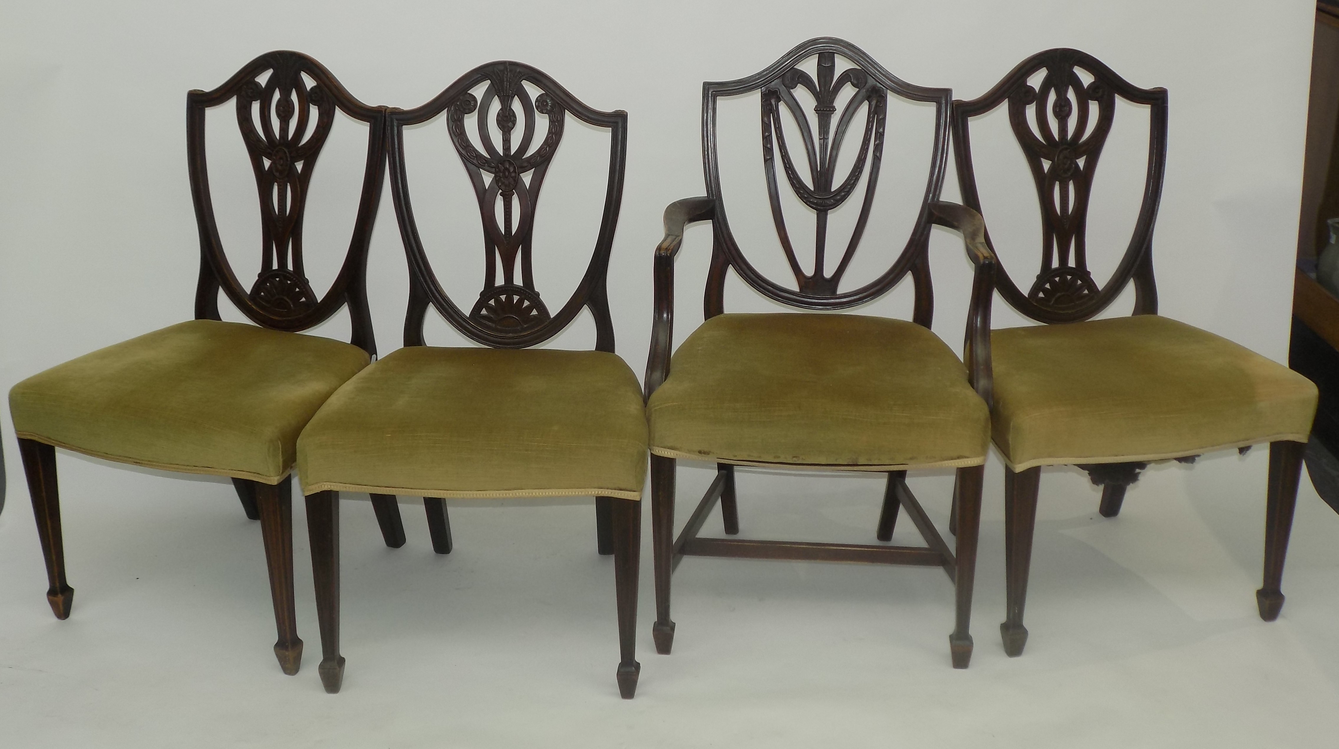 A set of three Hepplewhite style dining chairs, with carved shield back,