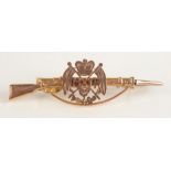 A WWI gold rifle and bayonet brooch.