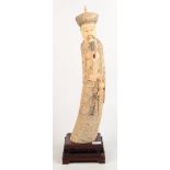 A Chinese ivory tusk carving of an emperor, circa 1900, on a mahogany stand, height 67cm.