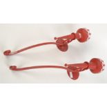 A pair of red painted metal, wall mounted candle sconces, length 53cm.