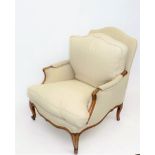 A French walnut upholstered armchair, with carved cabriole legs, height 96cm, width 65cm.