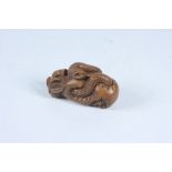 A Japanese carved wood netsuke of a snake in a gourd, signed, height 3.
