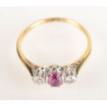 An 18ct yellow gold ring set an oval ruby flanked by diamonds.
