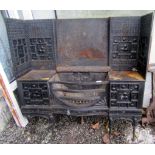 An Arts and Crafts black painted cast iron fireplace,