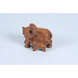 A Japanese carved wood netsuke of an elephant and her calf, signed, height 4cm, width 5cm.