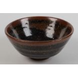 A studio pottery bowl with part Tenmoku glaze, height 7.5cm, diameter 15cm.