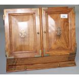 A mahogany stationary cabinet, the pair of doors each with brass inlaid navy anchor motif,