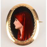 An 18ct gold mounted brooch set with a miniature enamelled portrait of a lady with a red shawl.