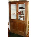 A Victorian pine corner cupboard, the pair of glazed doors enclosing three shelves,
