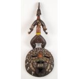 An African tribal wooden mask, decorated with shells, beadwork and brass, 38 x 34cm,