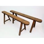 A pair of elm benches, late 19th century, two legs on one bench are later oak replacements,