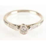 An 18ct white gold and platinum solitaire diamond ring set with a rubbed collet,