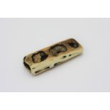 A ivory netsuke carved as a snake within a log, early 20th century, height 2cm, width 5.2cm.