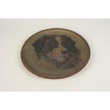 A Watcombe Torquay terracotta wall plaque, with painted decoration of a dog, diameter 32cm.