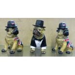 A pair of bulldog figures with Union Jack coats together with another dressed in a dinner suit and