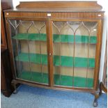 An early 20th century mahogany bow-fronted display cabinet with ball and claw feet, 122cm wide