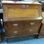 An Edwardian mahogany bureau with fitted interior over two short and one long drawer on turned and