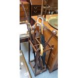 An oak open stick stand containing ten walking sticks/canes, umbrellas, shooting stick, etc.