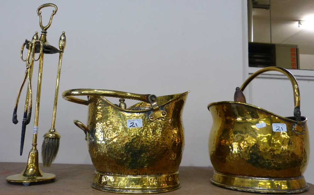 Two brass coal helmets and shovels together with a companion set