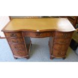A reproduction Regency style mahogany serpentine fronted double pedestal desk with inset top,