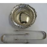 A silver pierced bowl, Birmingham 1899 with embossed decoration, a pair of Danish sugar tongs and
