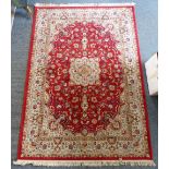 A red floral Persian style machine made rug, 240cm x 161cm