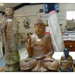 Two wooden figures of Buddha, 77cm and 53cm tall, together with another moulded resin oriental