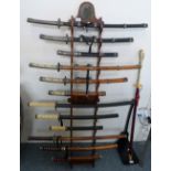 A Denix wall mounting wooden rack containing four Japanese Daisho sets of three swords