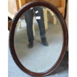 An oval wood frame bevel edged wall mirror