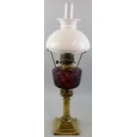A Victorian table oil lamp with brass stepped square base and short Corinthian column stem, amethyst