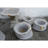 A pair of composition sack shaped planters together with a larger composition sack shape planter and