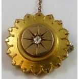 A Victorian gold and diamond target brooch, the central panel set with an old cut stone, locket